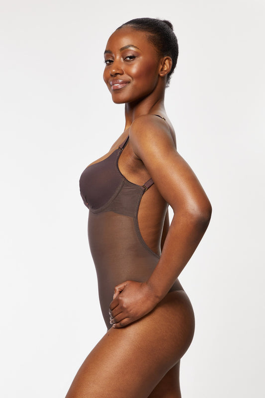 Seitliche Ansicht einer Frau in einem rückenfreien Body in Espresso-Farbe, der die nahtlose Passform und den tiefen Rückenausschnitt betont.